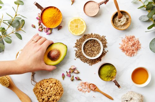 Overhead View Hand Arranging Natural Beauty And Health Products On Marble Background